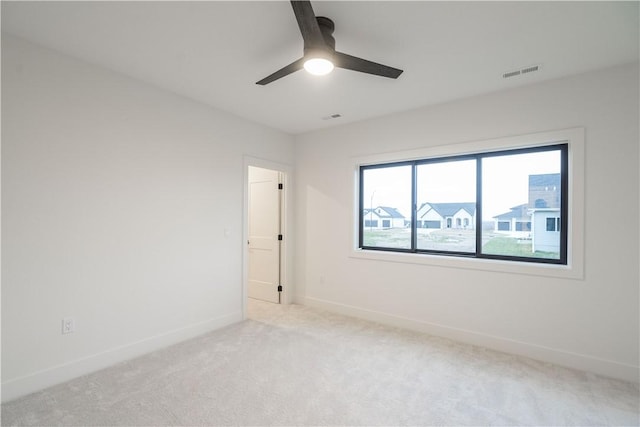 carpeted spare room with ceiling fan