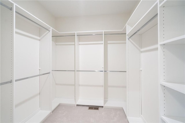 walk in closet featuring light colored carpet