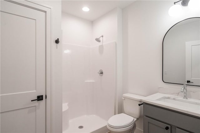 bathroom with toilet, a shower, and vanity