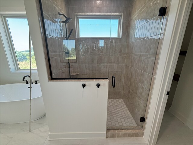 3034 NW Beechwood Dr, Grimes, IA 50111 - bathroom featuring a shower stall, healthy amount of natural light, a freestanding bath, and marble finish floors