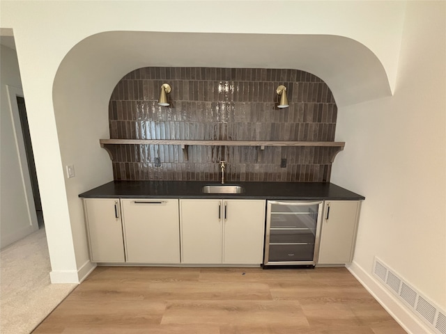 3034 NW Beechwood Dr, Grimes, IA 50111 - indoor wet bar with beverage cooler, tasteful backsplash, and light wood finished floors