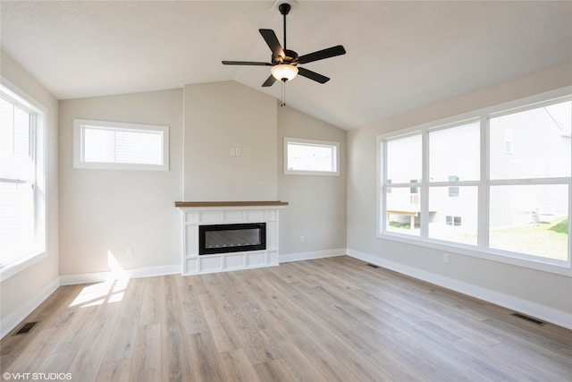 unfurnished living room featuring a glass covered fireplace, light wood-style floors, and visible vents