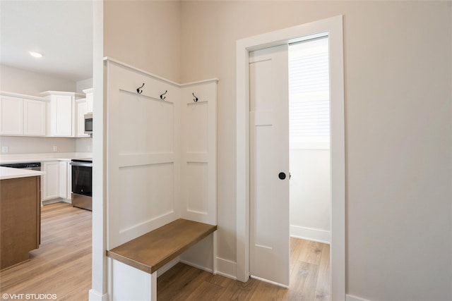 mudroom with baseboards and light wood finished floors