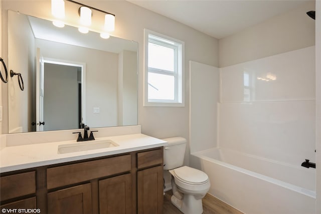 full bathroom featuring tub / shower combination, wood finished floors, toilet, and vanity