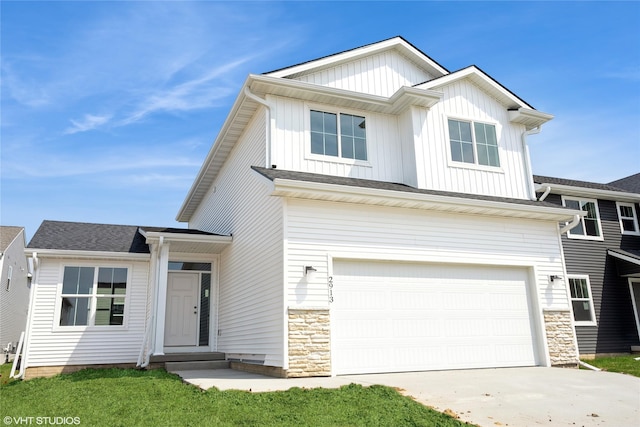 view of front of home featuring board and batten siding, an attached garage, stone siding, and concrete driveway