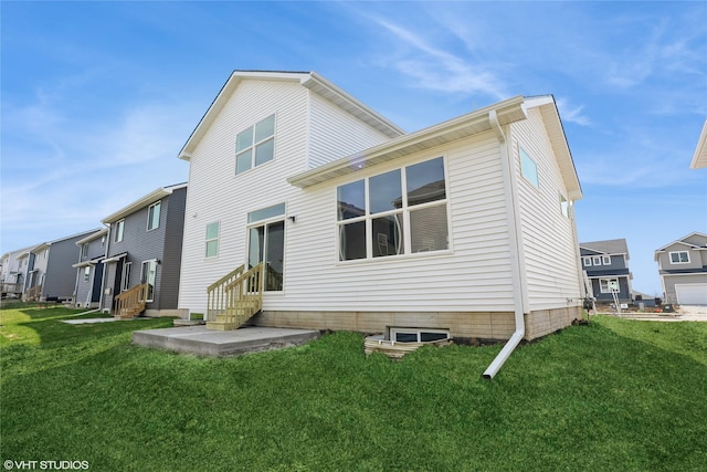 rear view of house with a yard, entry steps, and a residential view