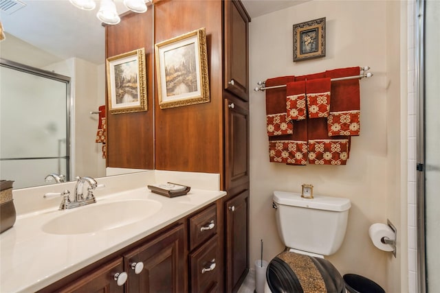 bathroom featuring toilet, a shower with shower door, and vanity