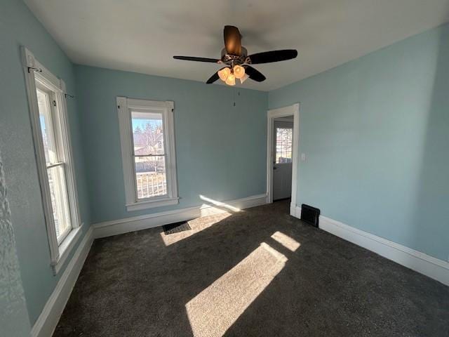 unfurnished room featuring dark colored carpet