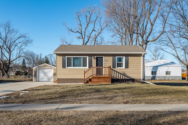 view of front of property with a garage, an outbuilding, and a front lawn