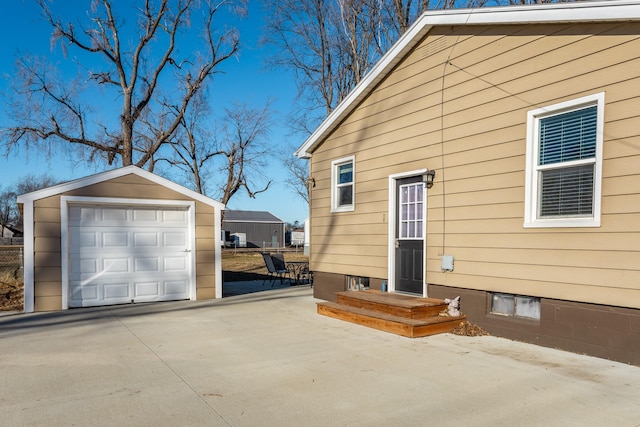 view of side of home with a garage and an outbuilding