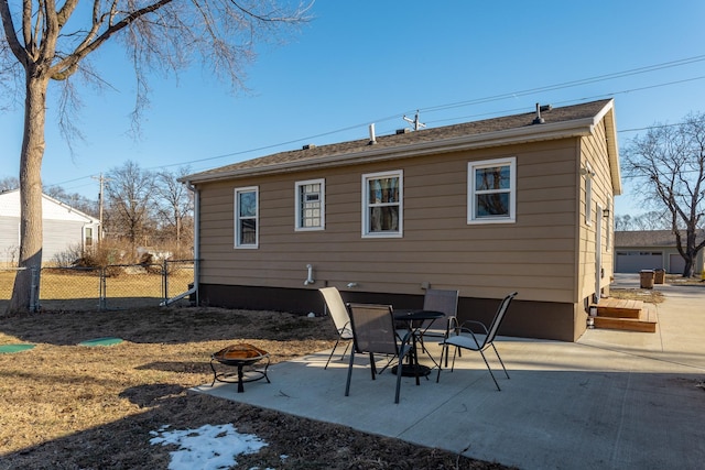 rear view of property featuring an outdoor fire pit and a patio area