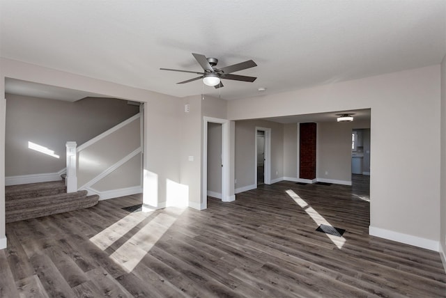 unfurnished living room featuring ceiling fan and dark wood-type flooring