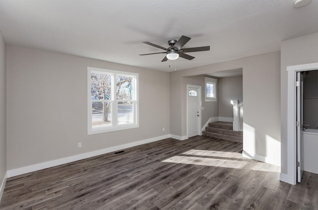 interior space with ceiling fan, a wealth of natural light, dark hardwood / wood-style flooring, and a textured ceiling