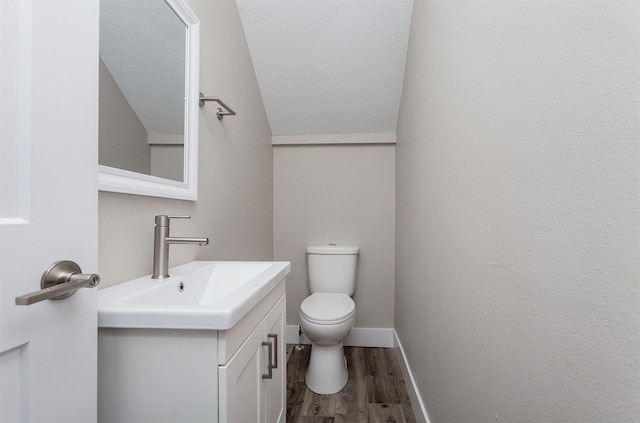 bathroom featuring a textured ceiling, hardwood / wood-style floors, toilet, and vanity