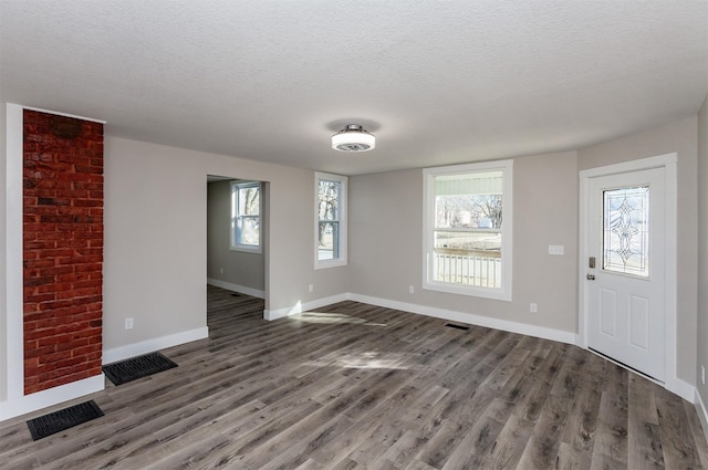 foyer featuring dark hardwood / wood-style floors and a textured ceiling