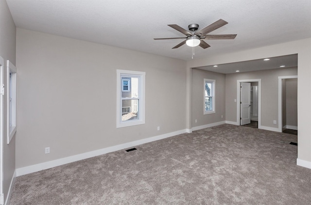 carpeted spare room with ceiling fan