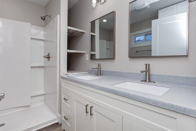 bathroom featuring walk in shower and vanity