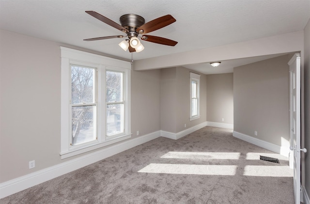 spare room with light colored carpet and ceiling fan