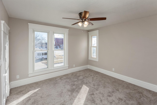 carpeted spare room with ceiling fan