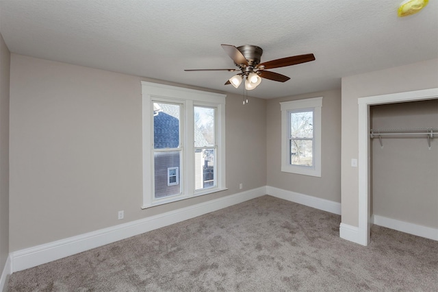 unfurnished bedroom with a closet, ceiling fan, a textured ceiling, and light carpet