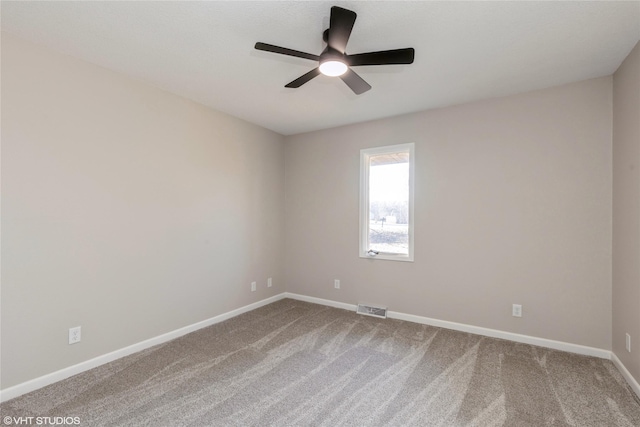 empty room featuring carpet floors, baseboards, visible vents, and ceiling fan