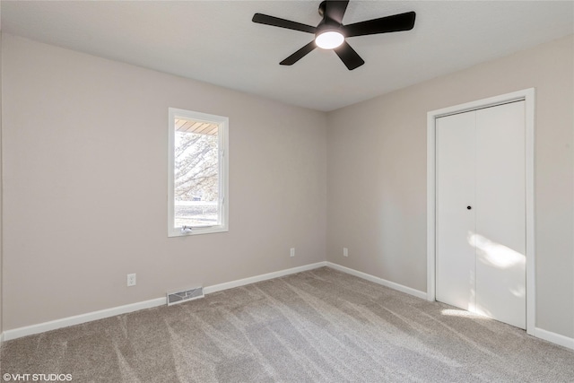 unfurnished room with baseboards, visible vents, and carpet flooring