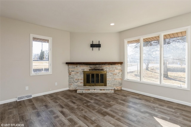 unfurnished living room with recessed lighting, visible vents, a glass covered fireplace, wood finished floors, and baseboards