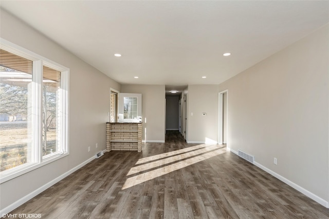 unfurnished living room featuring baseboards, visible vents, wood finished floors, and recessed lighting