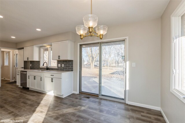 kitchen featuring a wealth of natural light, sink, pendant lighting, and white cabinets