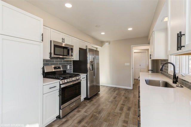 kitchen featuring sink, tasteful backsplash, dark hardwood / wood-style flooring, stainless steel appliances, and white cabinets