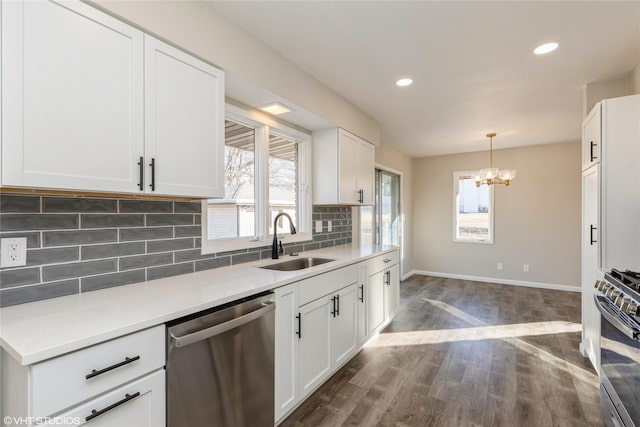 kitchen with dark wood-type flooring, sink, white cabinetry, stainless steel appliances, and backsplash