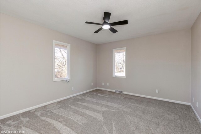 carpeted empty room featuring ceiling fan