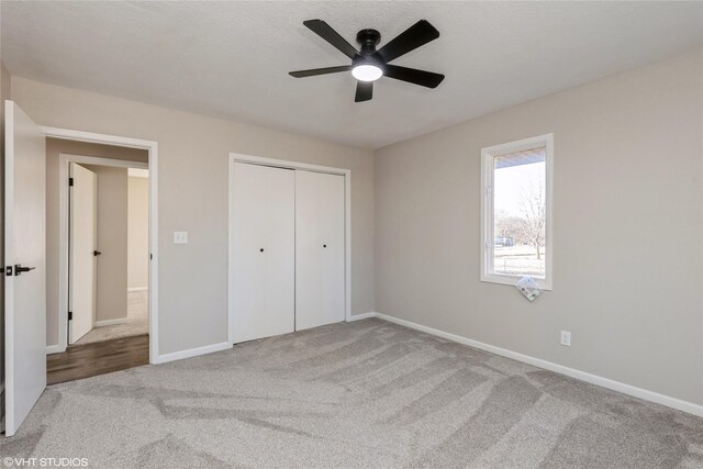 unfurnished bedroom with ceiling fan, carpet, and a closet