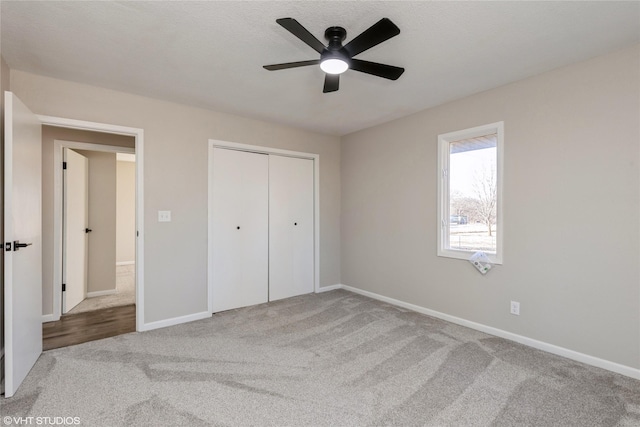 unfurnished bedroom featuring a closet, carpet flooring, ceiling fan, and baseboards