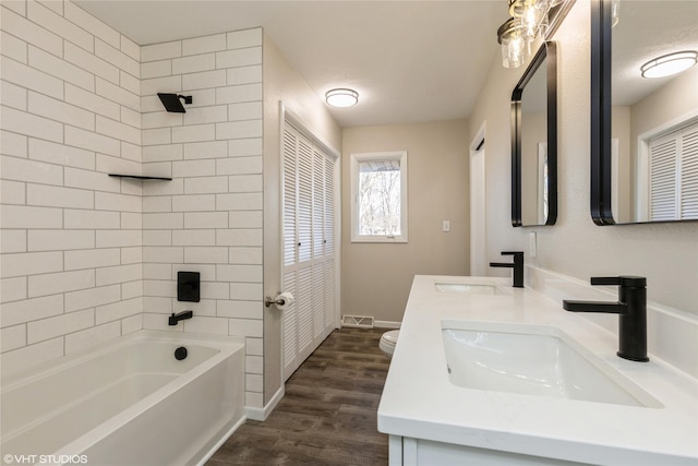 full bath with wood finished floors, a sink, visible vents, and shower / bathing tub combination