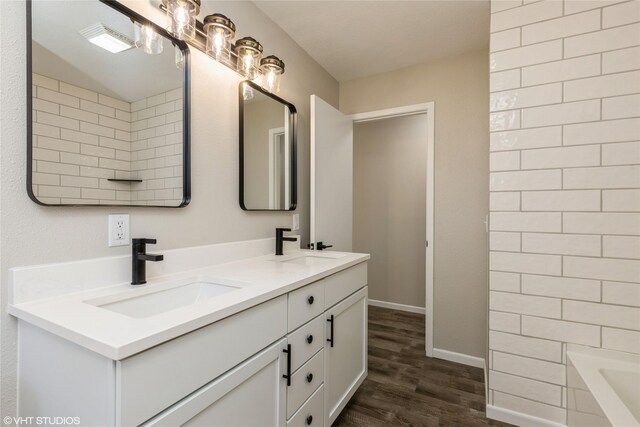 bathroom with vanity, hardwood / wood-style floors, and a bathtub