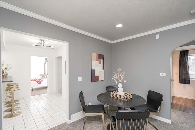 dining area featuring tile patterned floors, crown molding, a notable chandelier, and a textured ceiling