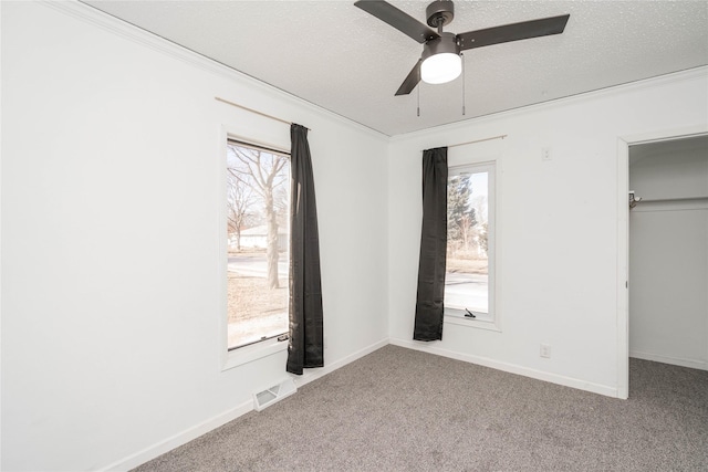 unfurnished bedroom with ceiling fan, light colored carpet, a textured ceiling, and a closet