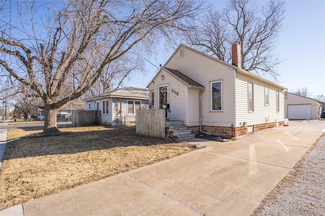 view of front of house with a garage, a front lawn, and an outdoor structure