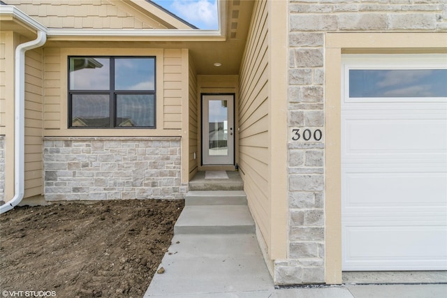 300 NW Ashley Ave, Waukee, IA 50263 - property entrance with a garage and stone siding