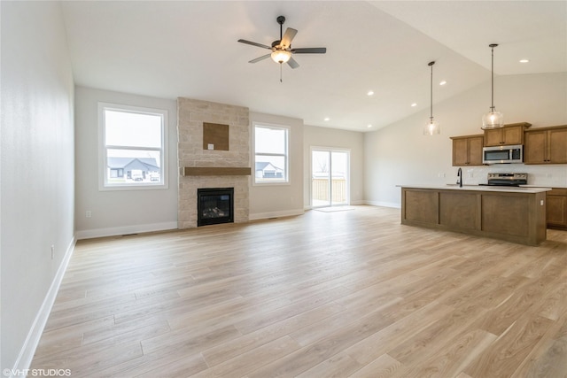 300 NW Ashley Ave, Waukee, IA 50263 - unfurnished living room with a sink, light wood-type flooring, a ceiling fan, and baseboards