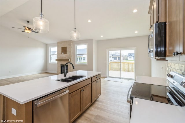 300 NW Ashley Ave, Waukee, IA 50263 - kitchen featuring light wood-style floors, ceiling fan, appliances with stainless steel finishes, a sink, and open floor plan