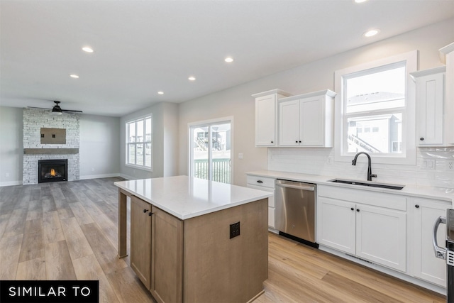 kitchen featuring sink, white cabinets, dishwasher, and a kitchen island