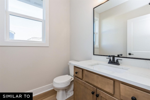 bathroom featuring wood-type flooring, toilet, and vanity