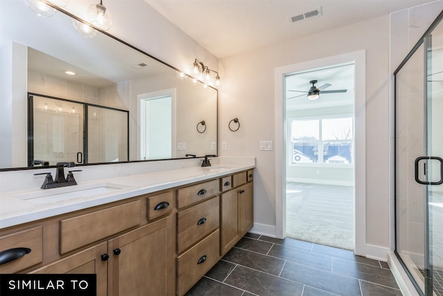 bathroom featuring a shower with shower door, vanity, and tile patterned flooring