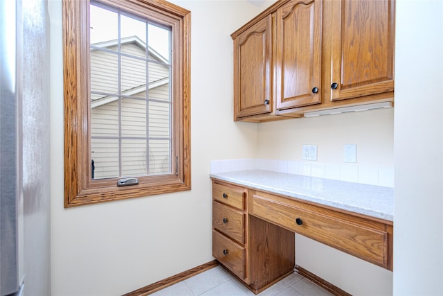 unfurnished office featuring light tile patterned flooring and baseboards