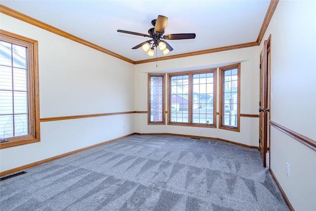 empty room featuring baseboards, visible vents, crown molding, and carpet flooring