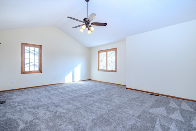 carpeted empty room with visible vents, vaulted ceiling, baseboards, and ceiling fan