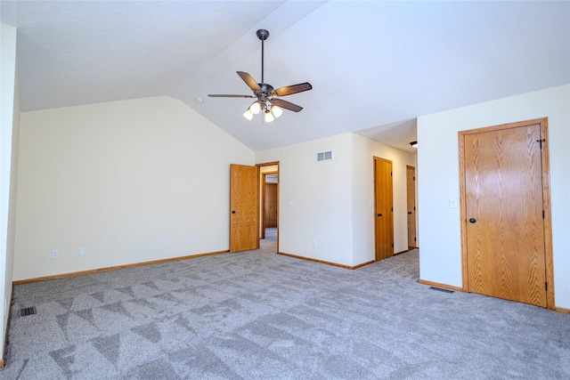 unfurnished bedroom with vaulted ceiling, carpet floors, visible vents, and baseboards