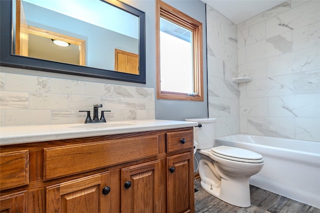 bathroom with tile walls, shower / bathtub combination, toilet, vanity, and wood finished floors